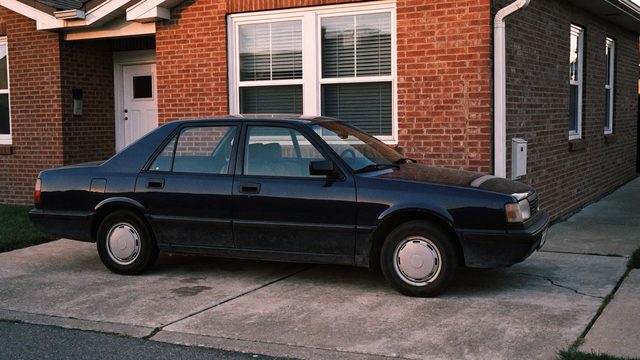 An ordinary, well-kept sedan parked in a plain driveway.